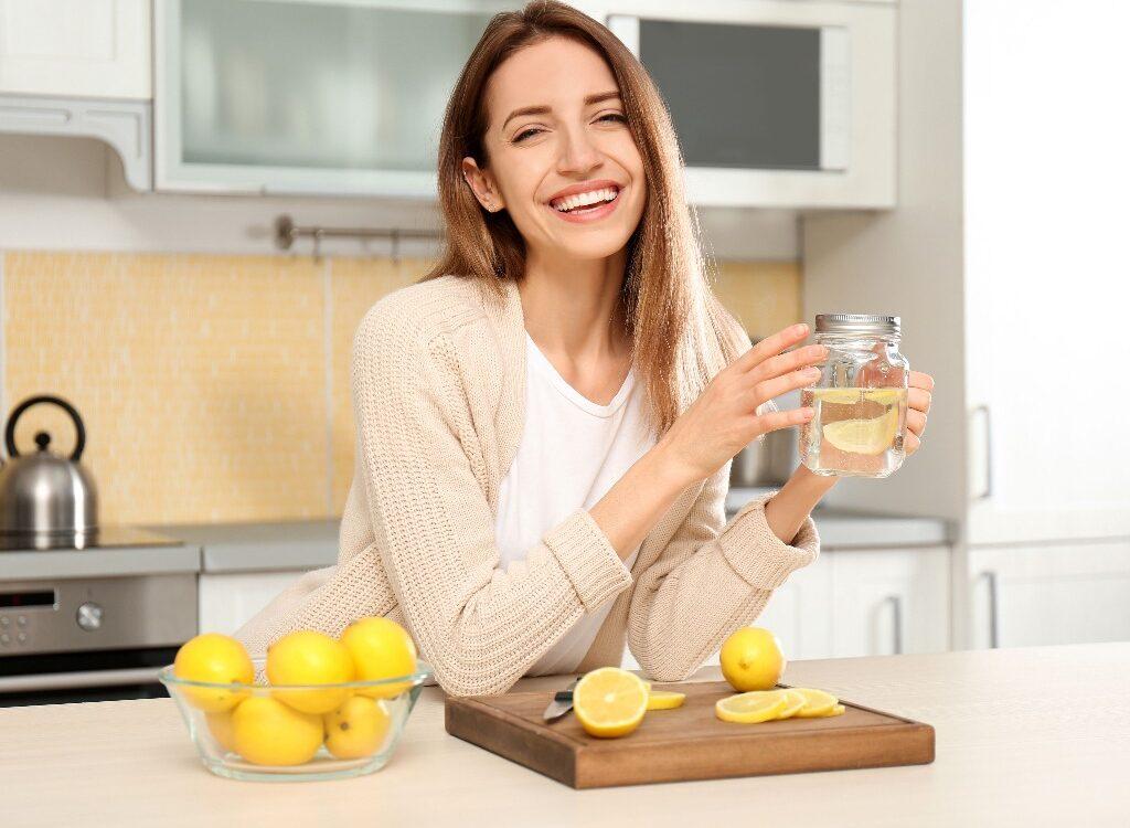 kobieta pije wodę z cytryną